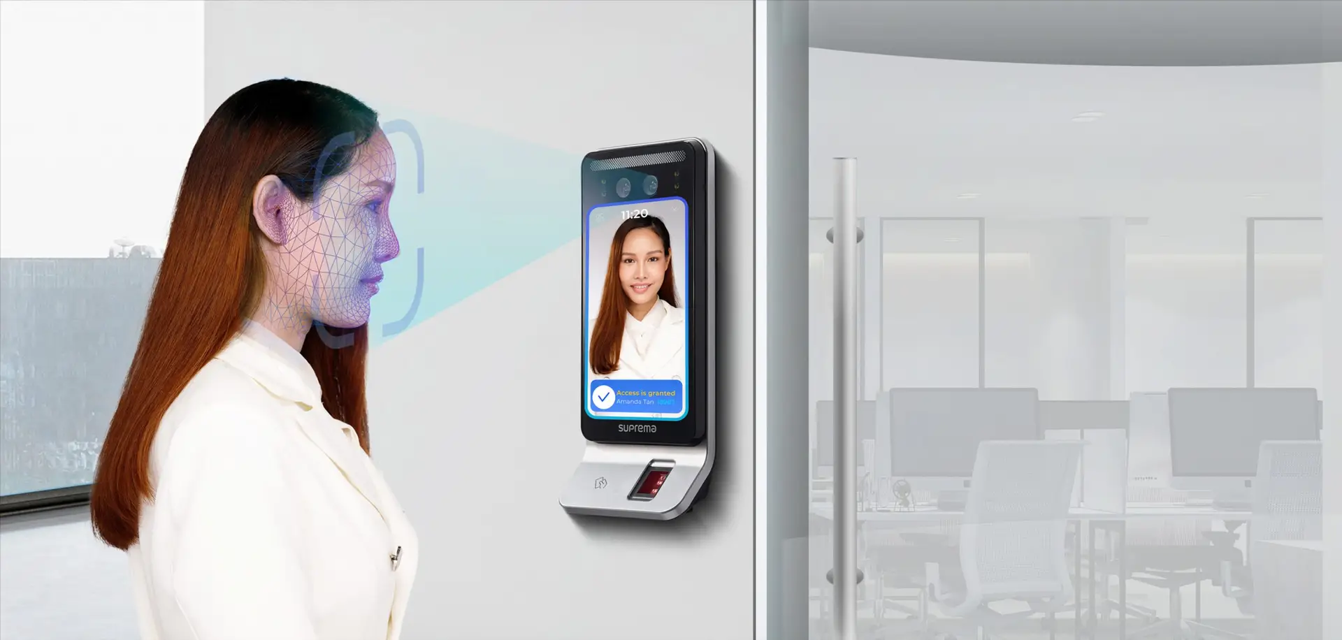 Person using a facial-recognition terminal for building access.